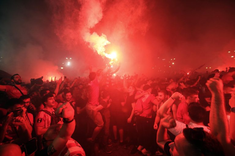 Los seguidores del Olympiacos encienden bengalas y fuegos artificiales mientras ven la retransmisión pública de lafinal de la Liga Conferencia que el Olympiakos ganó al Fiorentina. EFE/EPA/Alexander Beltes